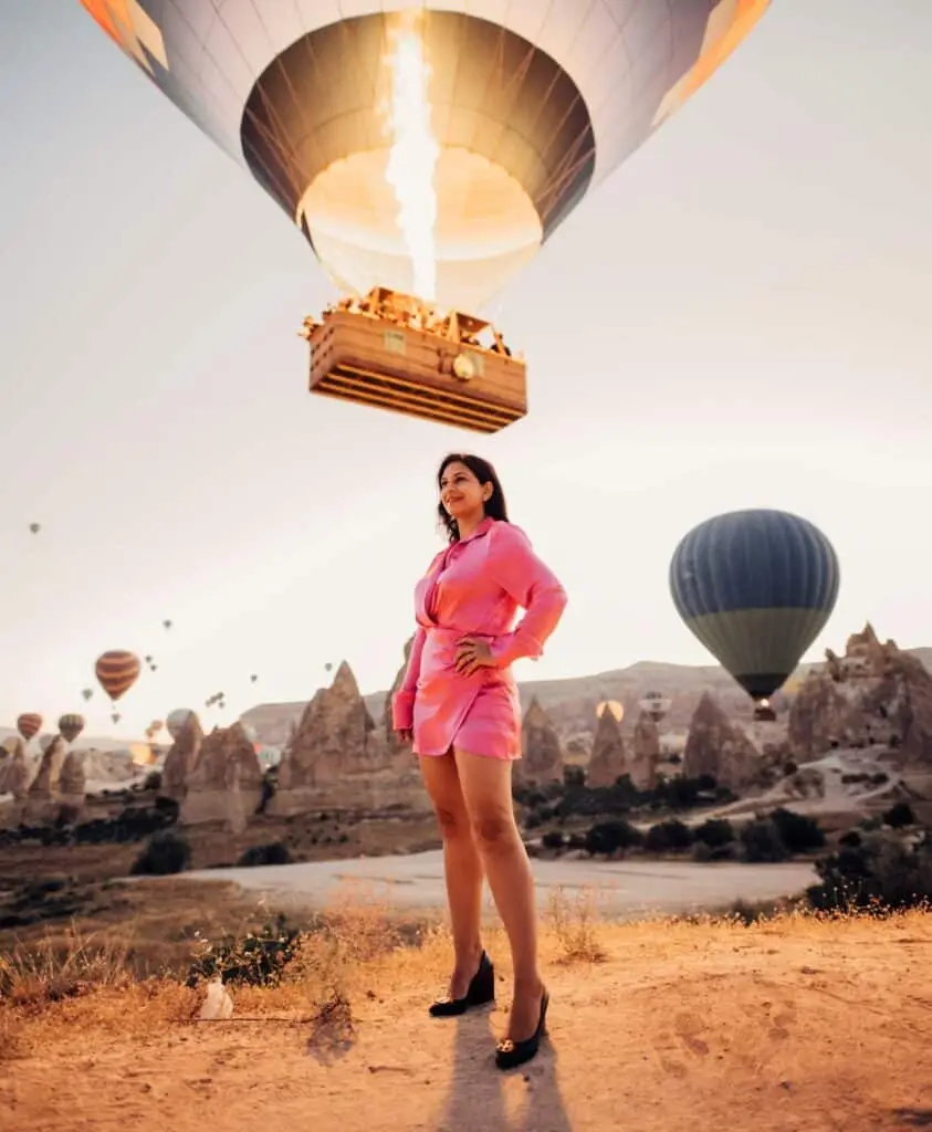 A colorful hot air balloon floating over the rocky landscapes of Cappadocia