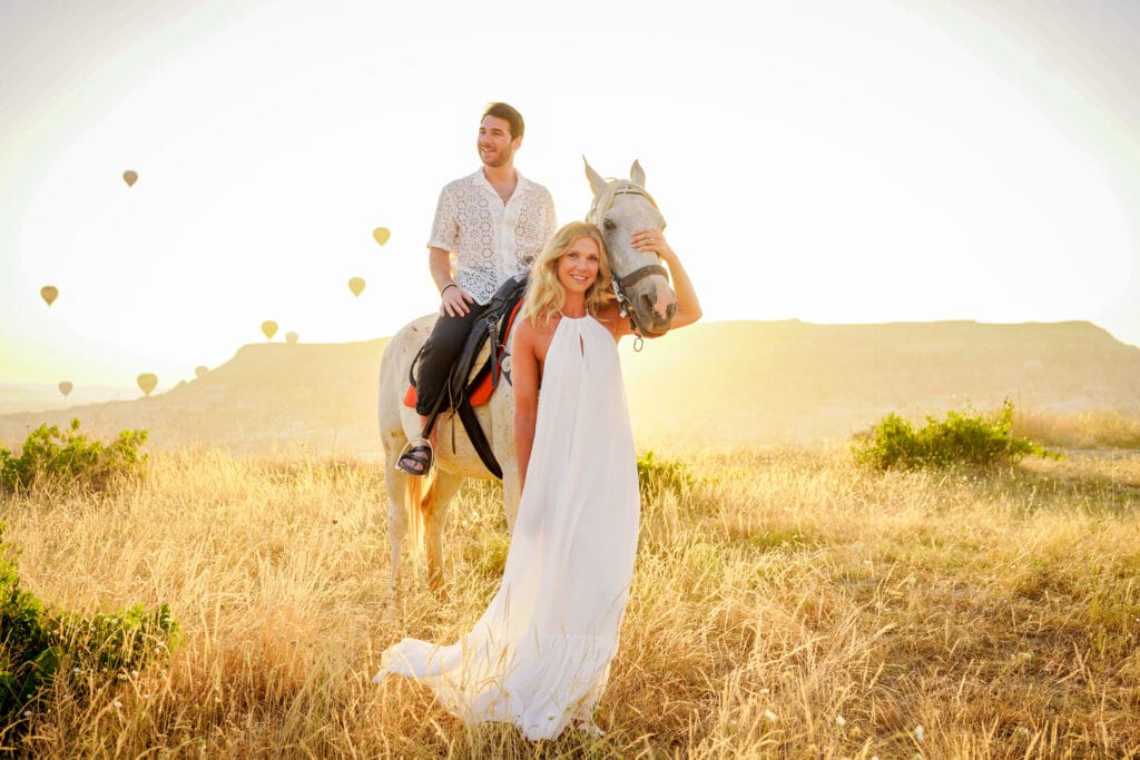 Sunset horseback ride in Cappadocia with hot air balloons in the background